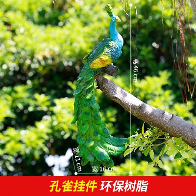 公園樹上擺放的樹脂彩繪孔雀雕塑