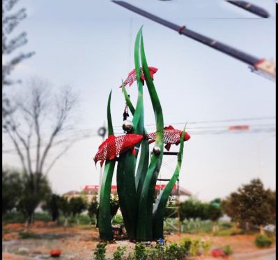 公園里擺放的水草里的不銹鋼創(chuàng)意鯉魚雕塑